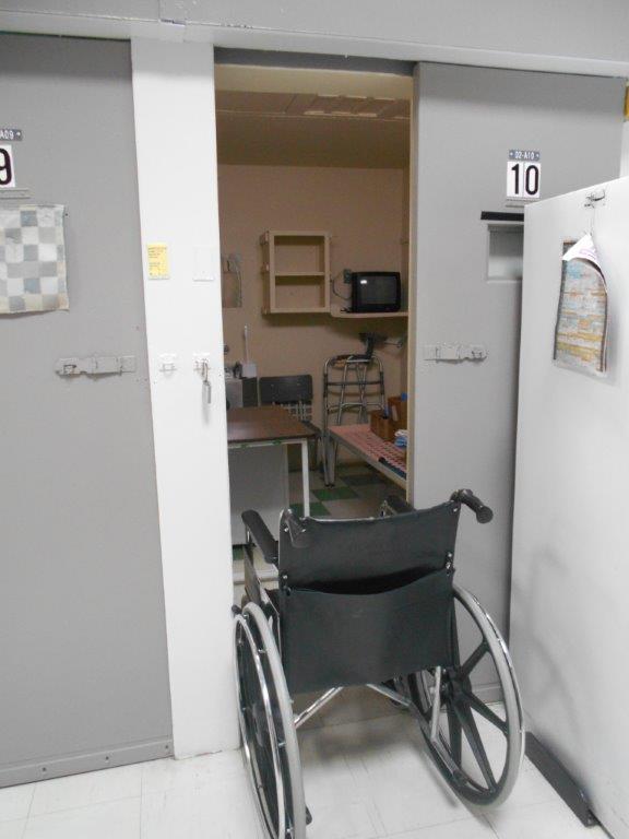 A picture of a wheelchair that cannot fit through a cell door.