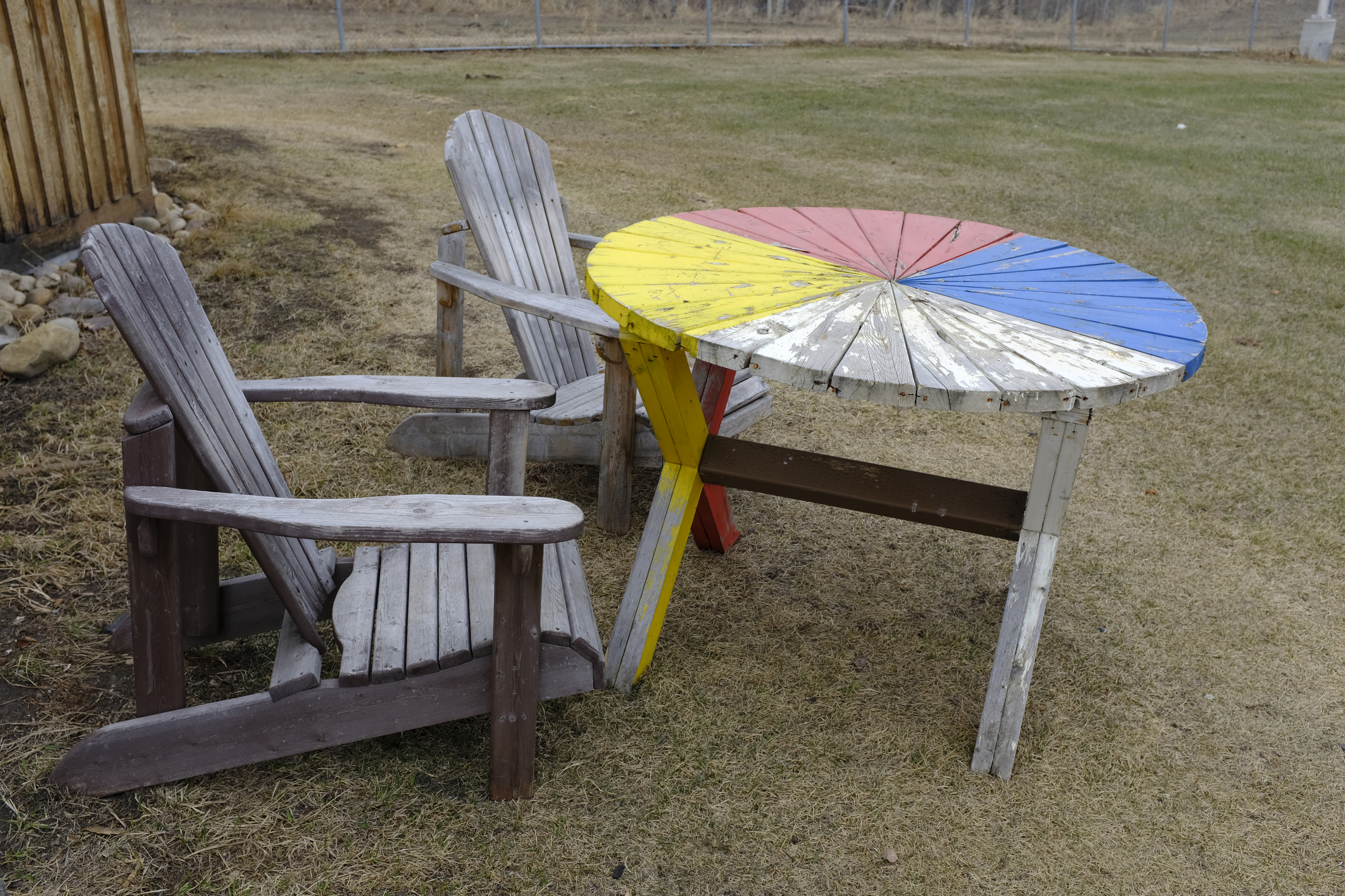 Photo de chaises et d’une table à l’extérieur d’une hutte de sudation au centre Pê Sâkâstêw.