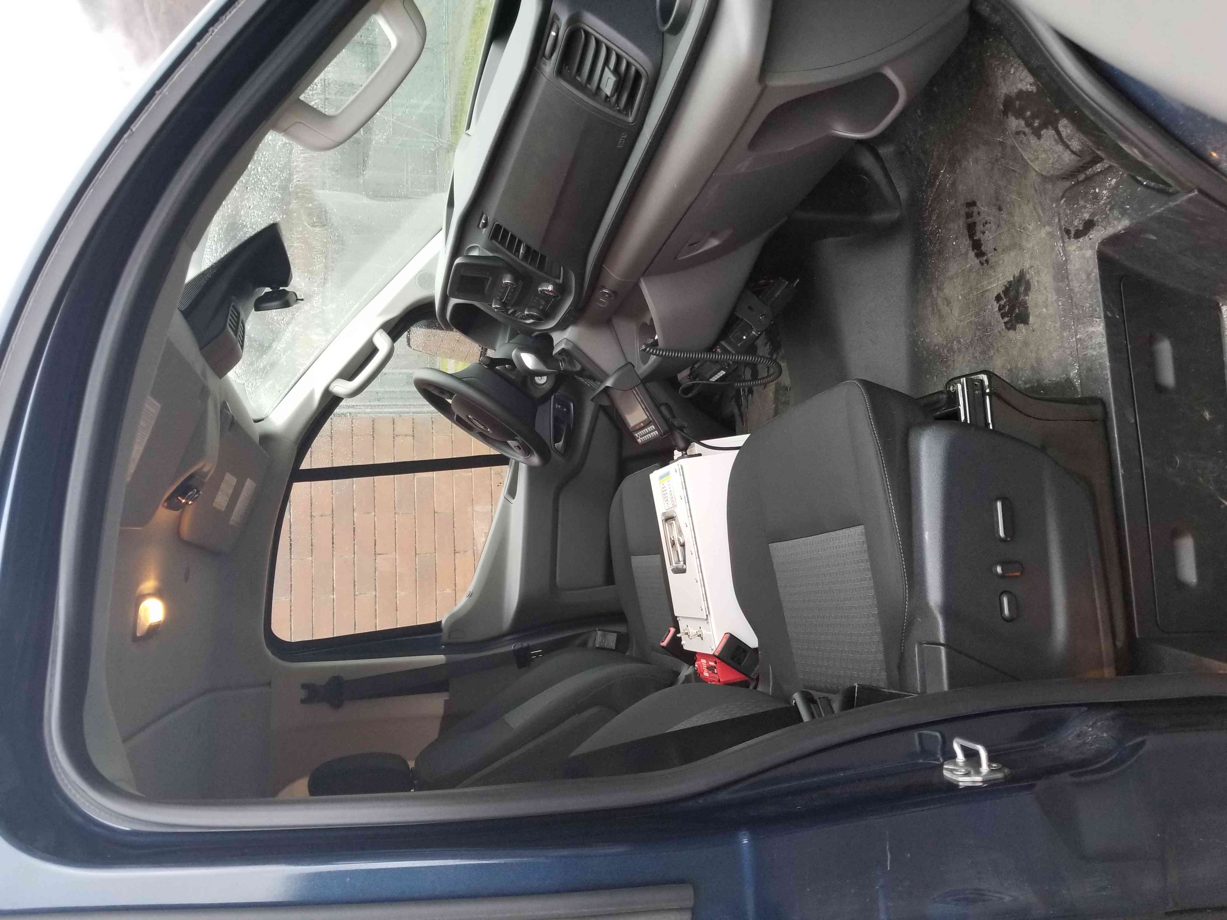 Photo of the driver and front passenger seats inside a CSC prisoner transport vehicle.