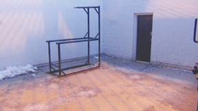 Photo of outdoor exercise yard showing concrete walls and metal bars.