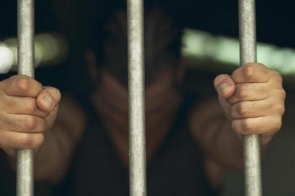 Photo of a man clutching bars